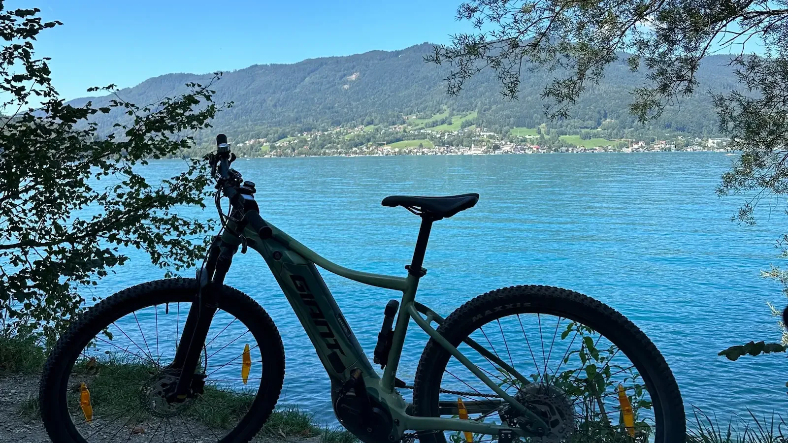 E-Bike am Ufer des Mondsees vor bewaldeten Hügeln