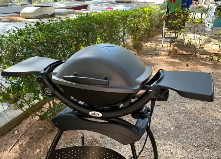 Weber Q1400 beim Camping vor dem Vorzelt: 230-V-Elektrogrill mit 2,2 kW, kompakt für 2–4 Personen – ideal für Campingplätze.
