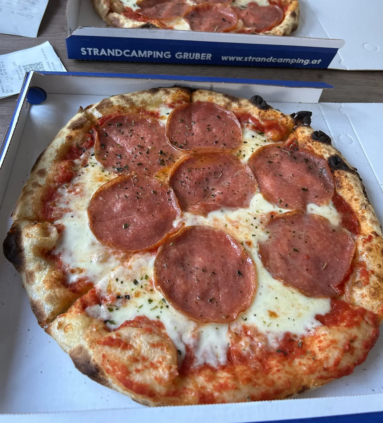 Salami-Pizza im Karton vom Restaurant bei Strandcamping Gruber