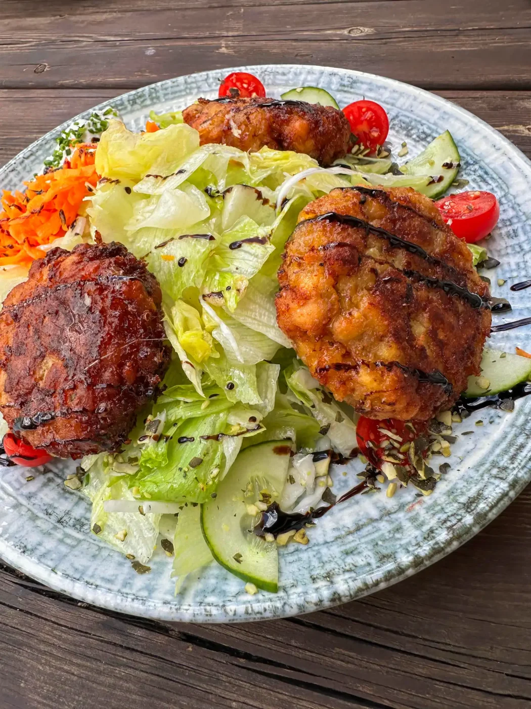 Ein Teller mit Kaspressknödel auf Salat, serviert auf der Egger Alm